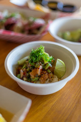 salmon poke over coconut rice topped with seaweed and lime