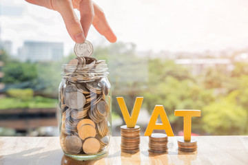 Vat Concept.Word vat with stacked coins and the hands are coin into the jar to accumulate money for paying vat.