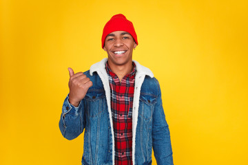 Smiling black guy showing away on yellow