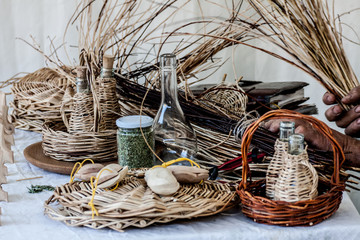 Produzione artigianale di bottiglie e cesti con vetro, vimini e paglia