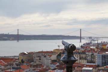 Fototapeta na wymiar Telescope on the observation deck of the castle with blurred cityscape of Lisbon - Portugal - point of view - copy space.