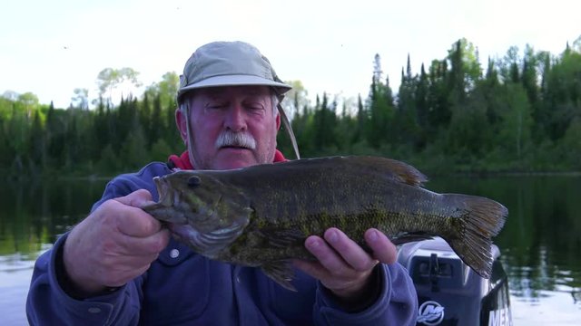 fisherman holds up big bass 4k depth of field