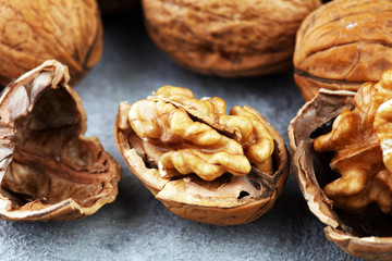 Walnut kernels and whole walnuts on rustic old table