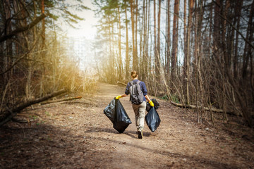 Recycle waste litter rubbish garbage trash junk clean training. Nature cleaning, volunteer ecology green concept. Young woman pick up spring forest at sunset . Environment plastic pollution