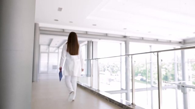 Young Female Doctor Walking Through Hospital Indoor