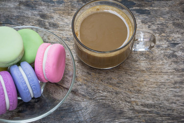 french macaron and cup of hot coffee on wooden table 