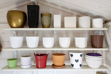 Fototapeta na wymiar Many pots in different shapes and sizes lined up on shelves in a garden shed.