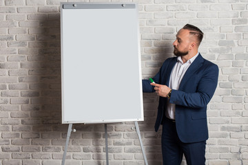 A teacher or business coach is standing next to a whiteboard for writing text. Board with copy...