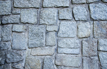 Wall of grey stones and concrete background texture