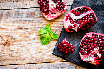 sliced pomegranate on wooden background top view