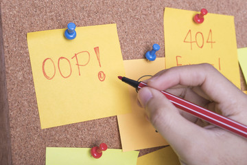 hand writing text 404 error and oops on sticky note.