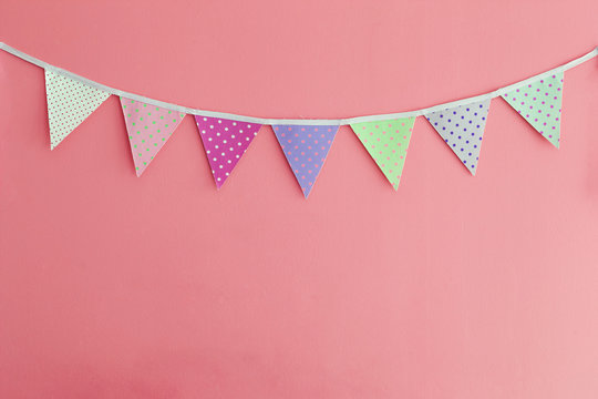 Color party bunting banner cotton triangle flag over red wall texture background