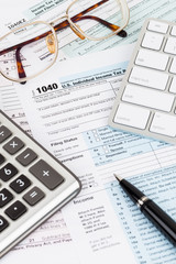 Naklejka na ściany i meble Tax form with calculator, pen, glasses, and keyboard