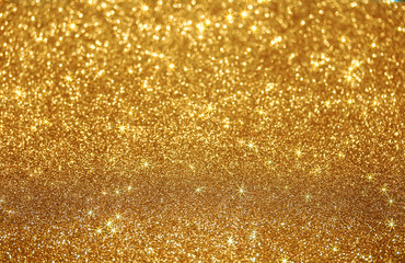 beautiful festive shiny Golden background of bright sparks and shimmering stars and specks