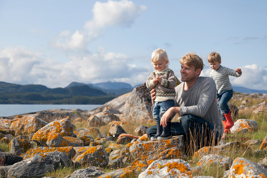 Man with sons playing by fjord, Aure, More og Romsdal, Norway