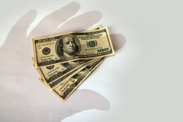 Shadow of the hand falls on money in dollars