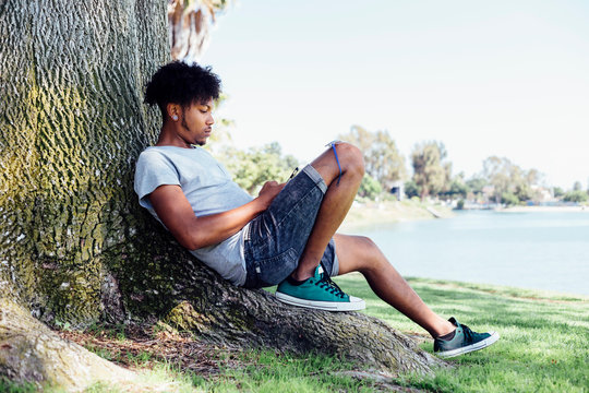 Man sitting on root of tree