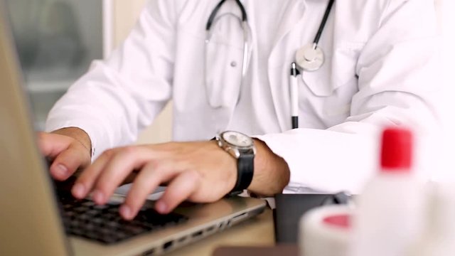 Doctor Typing On Laptop