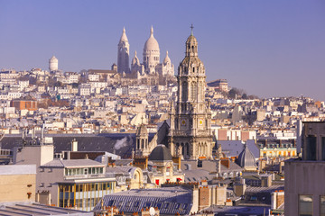 Fototapeta na wymiar Aerial view of Sacre-Coeur Basilica or Basilica of the Sacred Heart of Jesus at the butte Montmartre and Saint Trinity church in the morning, Paris, France