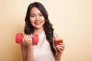 Healthy Asian woman with dumbbell and  tomato juice.