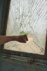 Men's hand is smashing a glass.