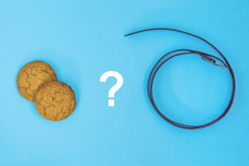 Carrot and stick concept. question sign between two gingerbreads and whip on blue background....