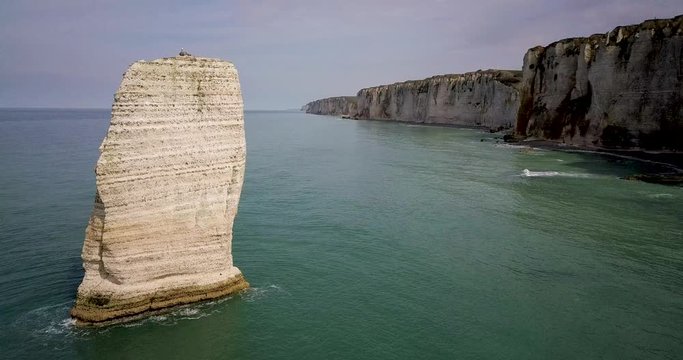 Drone footage of a standing limestone rock in open waters in Etretat Normandy France
