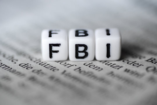 Word FBI formed by wood alphabet blocks on newspaper