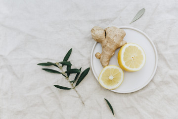 Flat lay lemon with ginger over linen tablecloth. Top view