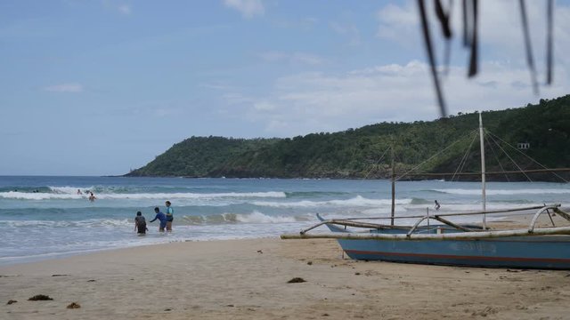 People in sea on tropical beach of Nagtabon Beach