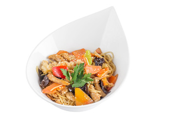 Egg noodles with meat and vegetables under teriyaki sauce isolated on white background. Egg noodles in a white plate.