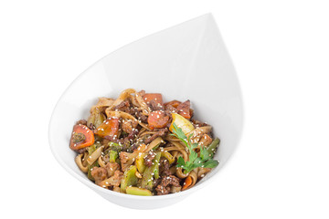 Wheat noodles with meat and vegetables under teriyaki sauce isolated on white background. Wheat noodles in a white plate.