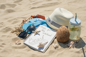 Hat, sunglasses, sunscreen, mojito on the beach, on white sand