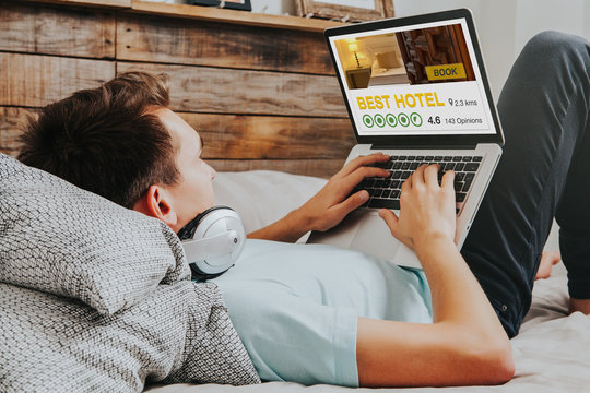 White man booking the best hotel by internet with a laptop computer at home.