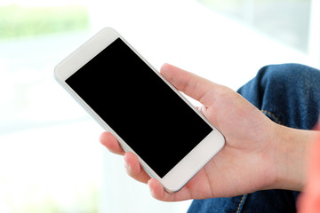 Man hand holding smartphone with blank screen on background for mock up, template, technology and lifestyle