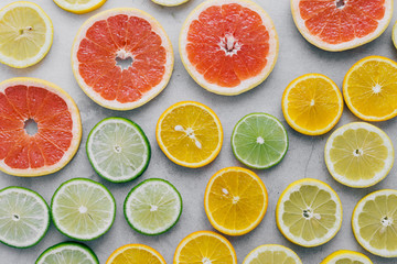 Colorful summer background. Different citrus fruits on white background close up. Lemon, lime, orange and grapefruit on a light background