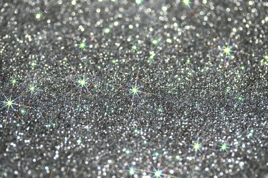 beautiful festive silver shiny background with bright sparks and shimmering stars and circles