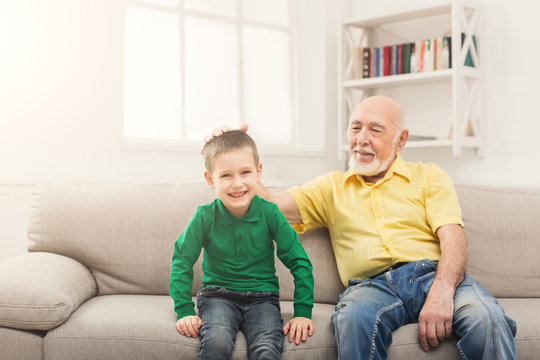 Little boy sitting on couch with his grandfather