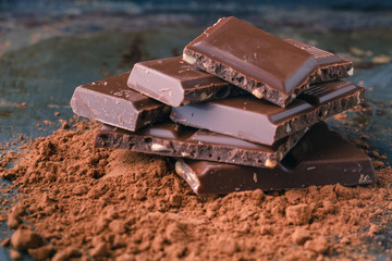 Natural dark chocolate pieces on wooden table