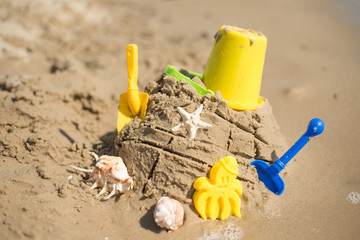 A sand castle with toys on the beach or the ocean