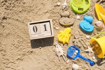 Children's toys and sand with a calendar on June 1, on the beach. International Children's Day