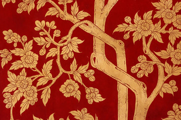 Traditional red painting depicting trees and leaves on a door at the the Wat Phra Kaew Palace, also...