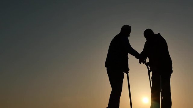 2 elders meets and shake arms silhouettes isolated 