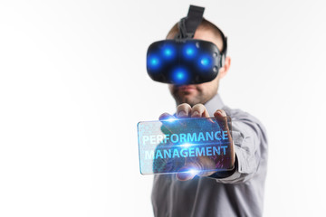 Business, Technology, Internet and network concept. Young businessman working in virtual reality glasses sees the inscription: Performance management