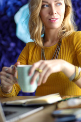 Young woman on a coffee break or enjoying the coffee-break, Using laptop computer