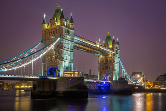 London, England - Iconic illuminated Tower Bridge by night with purple sky