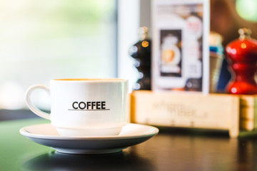 Latte Coffee in a cup on wooden table and Coffee shop blur background