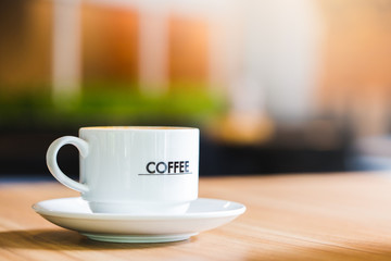Latte Coffee in a cup on wooden table and Coffee shop blur background