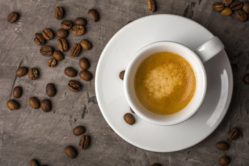 White cup with coffee and whole grains. View from above. Dark background