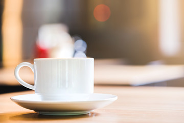 Latte Coffee in a cup on wooden table and Coffee shop blur background